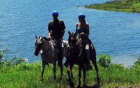 Ride horses along the shore of Lake Arenal