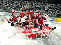 White water rafting surrounded by rainforest-covered mountains